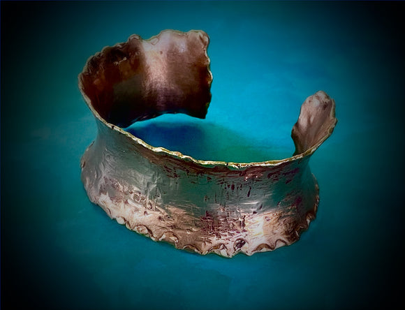 Anticlastic hand forged copper cuff with melted edge